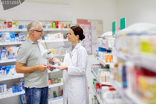 Image of pharmacist and senior man buying drug at pharmacy