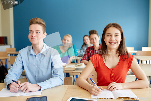 Image of happy students with notebooks at school