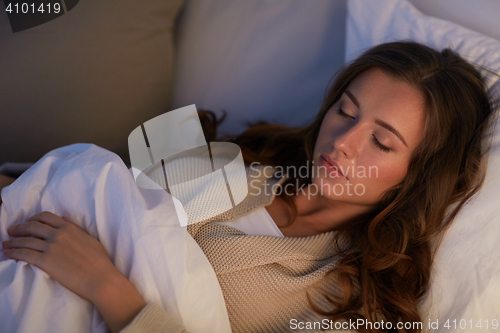 Image of young woman sleeping in bed at home