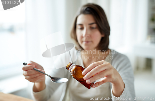 Image of woman pouring medication from bottle to spoon