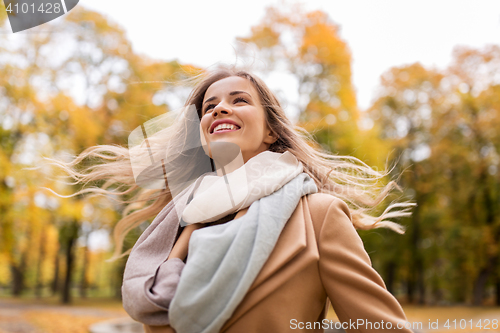 Image of beautiful happy young woman walking in autumn park