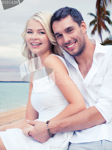 Image of couple having fun and hugging on beach