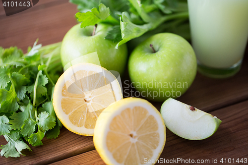 Image of close up of lemons, apples, celery and green juice