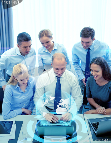 Image of smiling business people with laptop in office