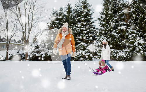 Image of happy family with sled walking in winter outdoors