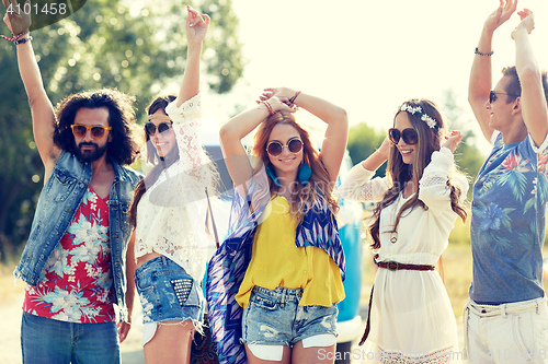 Image of happy young hippie friends dancing outdoors