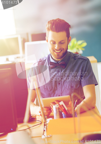 Image of happy creative male office worker with tablet pc