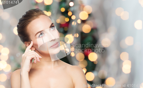 Image of beautiful woman thinking over christmas lights