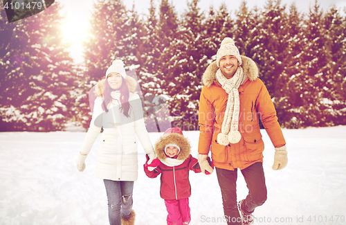 Image of happy family in winter clothes walking outdoors