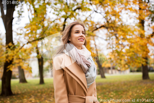 Image of beautiful happy young woman walking in autumn park