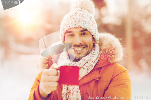 Image of happy man with tea cup outdoors in winter