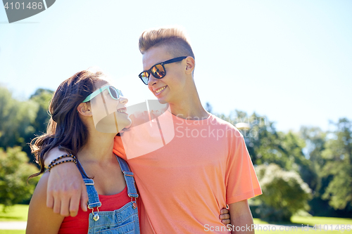 Image of happy teenage couple looking at each other in park