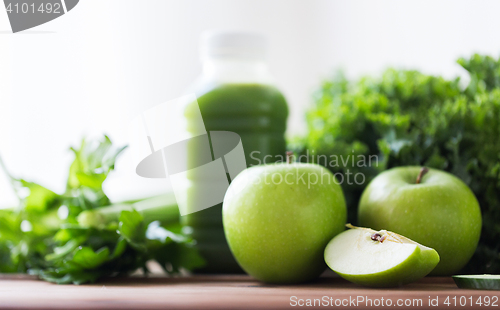 Image of close up of bottle with green juice and vegetables