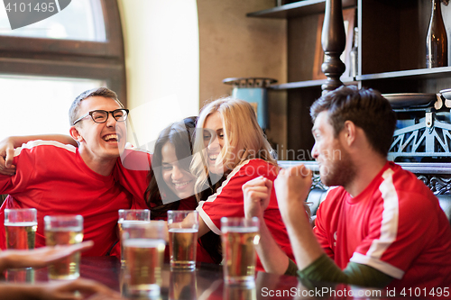 Image of football fans or friends with beer at sport bar