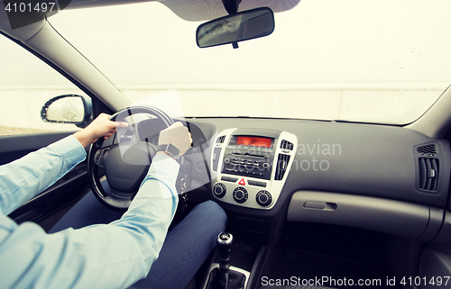 Image of close up of young man driving car