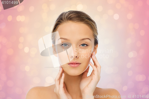 Image of young woman touching her face