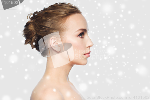 Image of beautiful young woman face over snow