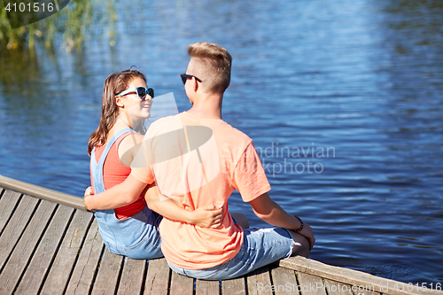 Image of happy teenage couple hugging on river berth