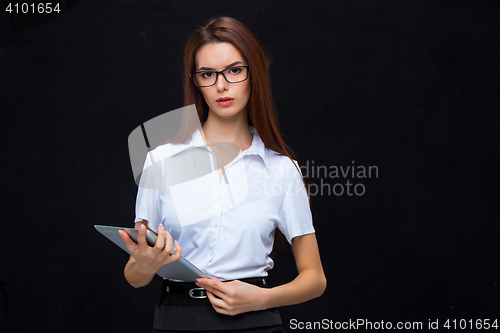 Image of The young business woman with tablet on black background