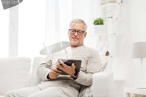 Image of senior man with tablet pc at home