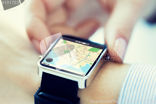 Image of close up of hands with map on smartwatch screen