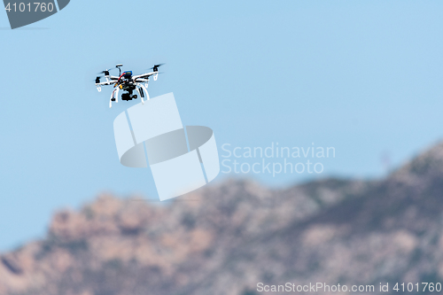 Image of Drone with camera hovering over mountains