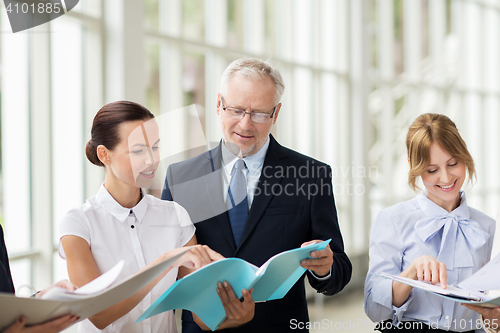 Image of business team with folders meeting at office