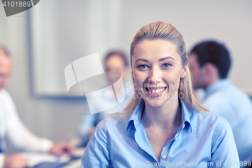 Image of group of smiling businesspeople meeting in office