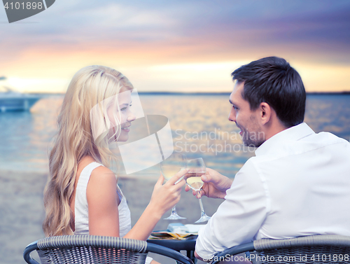Image of couple drinking wine in cafe on beach