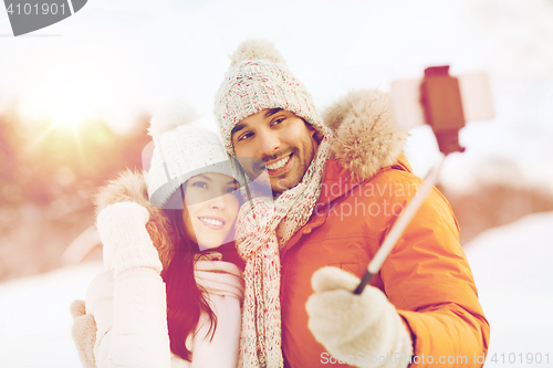 Image of happy couple taking selfie by smartphone in winter