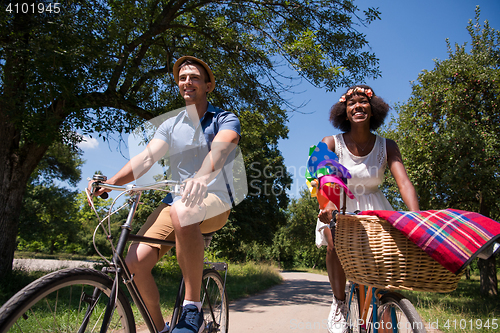 Image of Young multiethnic couple having a bike ride in nature