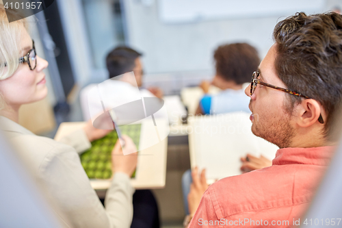 Image of group of students with notebooks in lecture hall