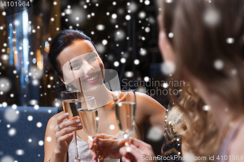 Image of happy women with champagne glasses at night club