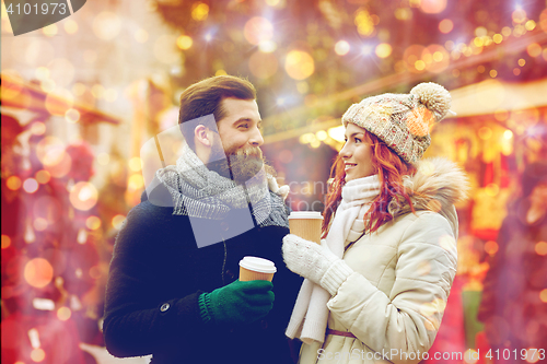 Image of happy couple drinking coffee on old town street