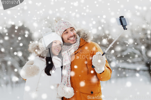 Image of happy couple taking selfie by smartphone in winter