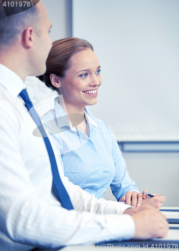 Image of group of smiling businesspeople meeting in office