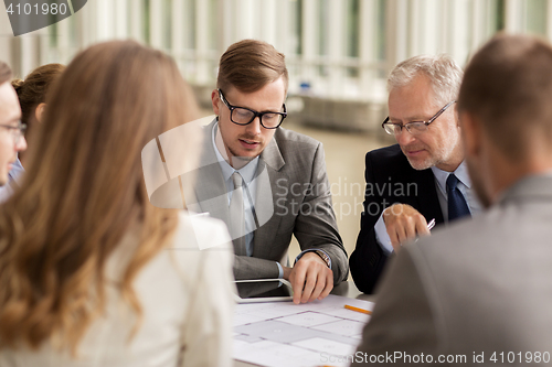 Image of architects with blueprint and tablet pc at office