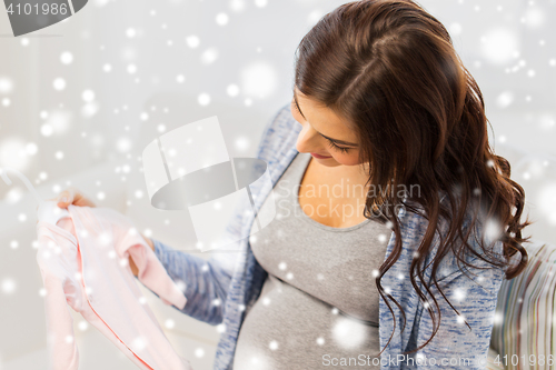 Image of close up of happy woman with baby bodysuit at home