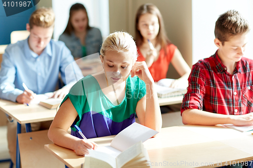 Image of group of students with books writing school test