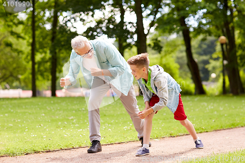 Image of grandfather and grandson racing at summer park