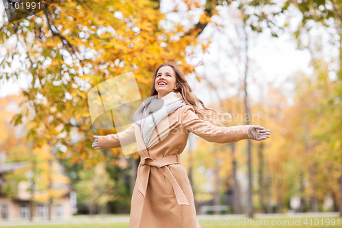 Image of beautiful happy young woman walking in autumn park