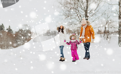 Image of happy family in winter clothes walking outdoors