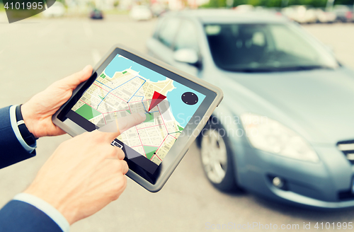 Image of close up of hands with gps on tablet pc and car