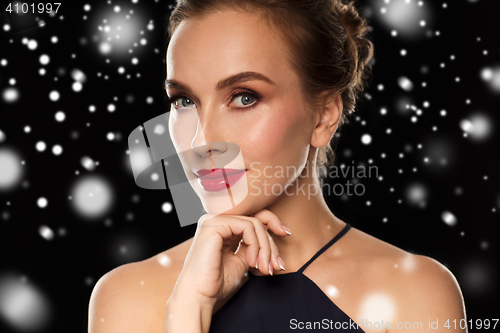 Image of close up of beautiful woman in black over snow