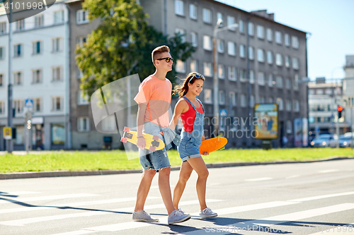 Image of teenage couple with skateboards on city street