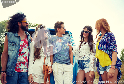 Image of smiling young hippie friends over minivan car