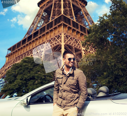 Image of happy man near cabriolet car over eiffel tower