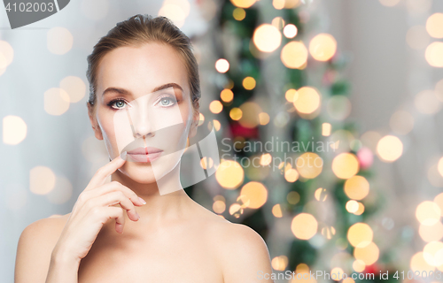 Image of beautiful woman showing lips over christmas lights