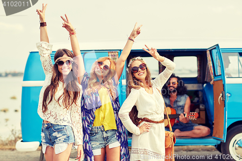 Image of happy hippie friends having fun over minivan car