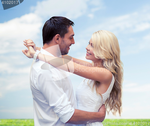 Image of happy couple hugging over natural background